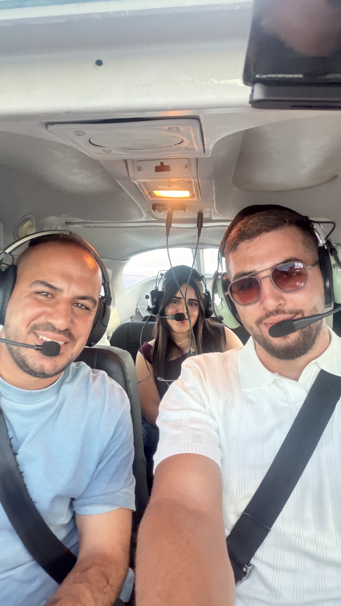 שלושה נוסעים עם אוזניות בתא המטוס